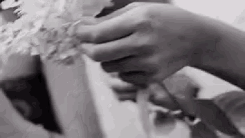 a black and white photo of a person holding a flower .