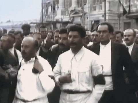 a man with a mustache is walking in a crowd