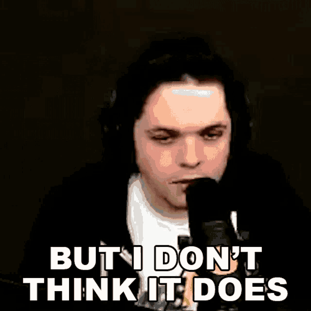 a man wearing headphones is talking into a microphone and saying `` but i don 't think it does ''