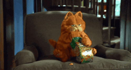 a cartoon cat is sitting in a chair eating a bag of chips