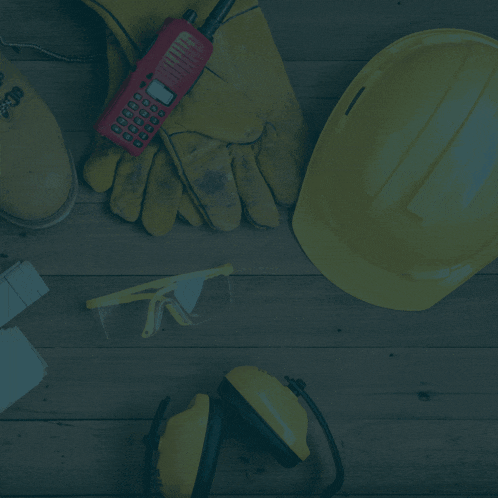 a hard hat gloves and a cell phone on a wooden table