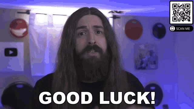 a man with long hair and a beard is giving a good luck sign .