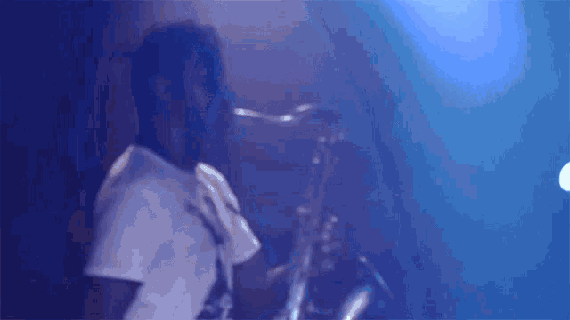 a man playing a saxophone in a dark room