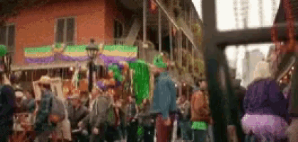 a crowd of people are gathered on a street during mardi gras