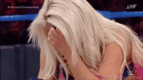 a woman is covering her face with her hands during a wrestling match on a television screen .