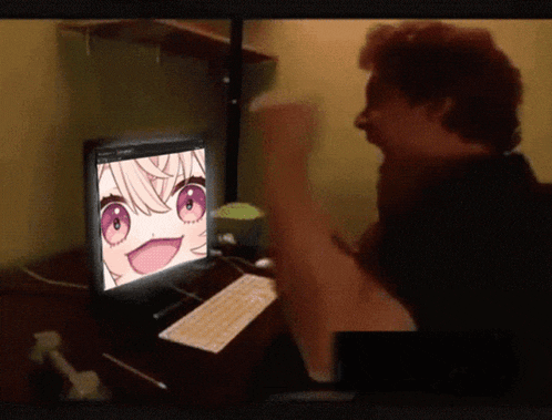 a man is sitting in front of a computer screen with a girl on it