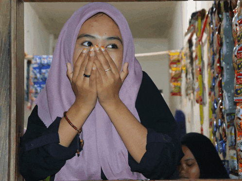 a woman with a ring on her finger is covering her mouth