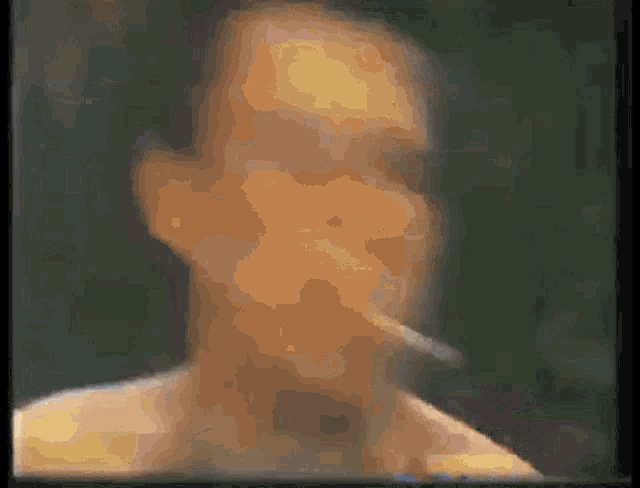 a man smoking a cigarette in a blurry photo