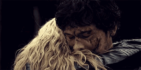 a man and a woman hugging each other in a dark room .