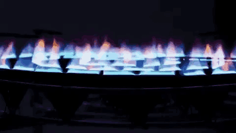 a close up of a stove with blue flames on it