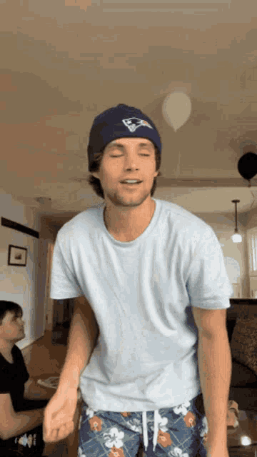 a man wearing a beanie and hawaiian shorts is dancing