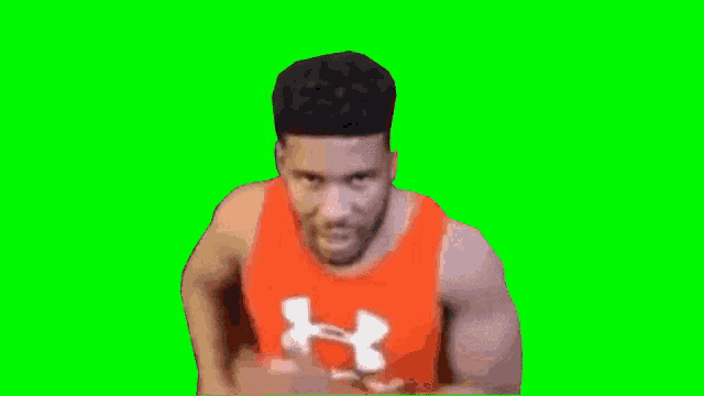 a man wearing a red under armour tank top on a green screen .
