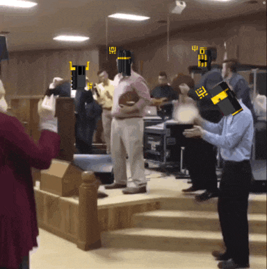 a group of people standing in a room with a man wearing a mask that says ' i ' on it