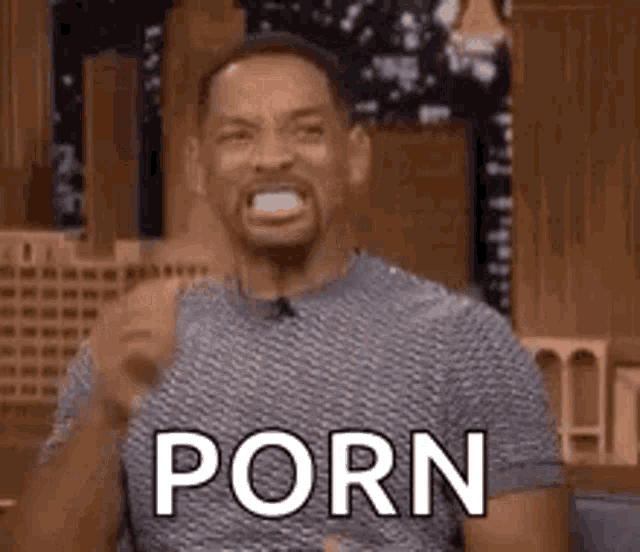 a man is making a funny face while holding a piece of paper in his mouth .