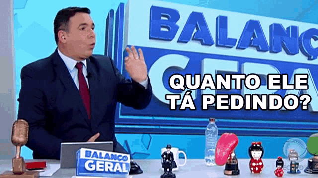 a man in a suit and tie is standing in front of a sign that says balanco geral