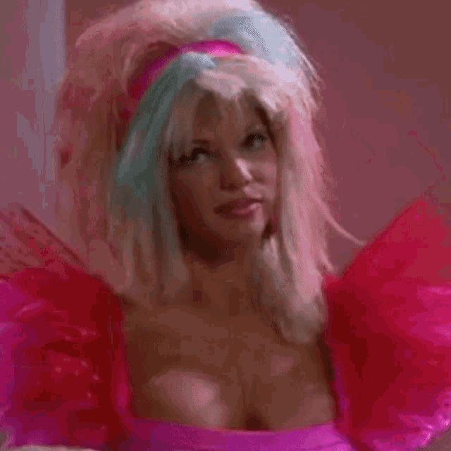 a woman with blonde hair and a pink dress is wearing a pink wig .