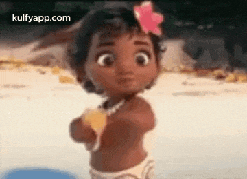 a baby girl with a flower in her hair is standing on the beach .