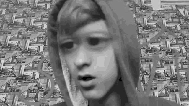 a black and white photo of a boy wearing a hooded jacket
