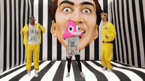 a group of people are dancing in front of a statue of a man with a pink poop in his mouth