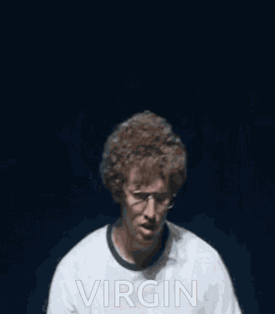 a man wearing glasses and a watch is making a funny face with his hands in the air and the word virgin behind him
