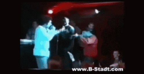 a man singing into a microphone with the website www.b-stadt.com visible in the corner