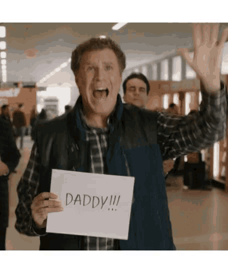 a man holding a sign that says daddy !!!