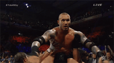 a wrestler is laying on the floor in a wrestling ring .