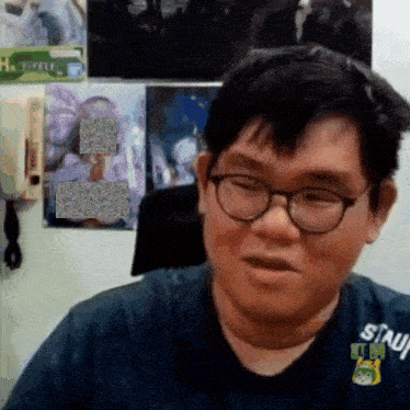 a man wearing glasses and a shirt that says ' sinji ' on it