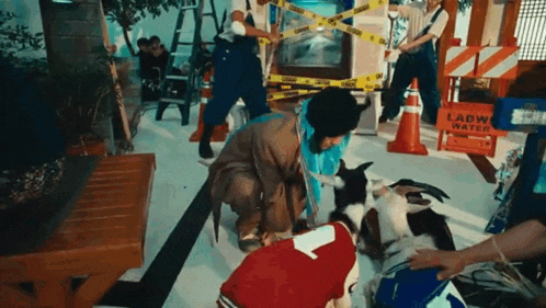 a woman is petting a goat in a room with a lot of people .