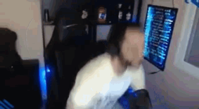 a man is sitting in front of a computer screen .