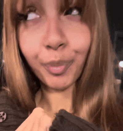 a close up of a woman 's face with a smiley face on her shirt