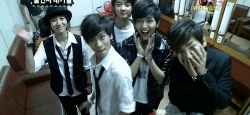 a group of young men are posing for a picture in a dressing room with a sign that says ' korean ' on it