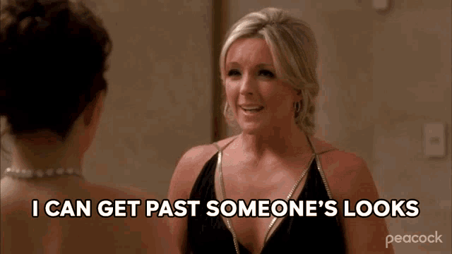 a woman in a black dress is talking to another woman and says i can get past someone 's looks