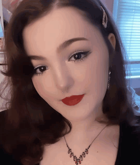a woman with red lips and a nose ring