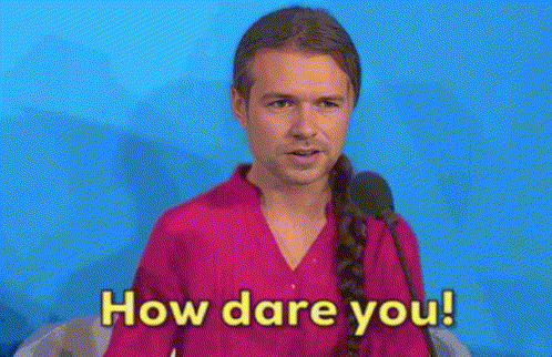 a man in a pink shirt is talking into a microphone and says how dare you