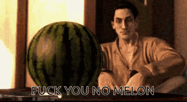 a man sitting next to a watermelon that says " fuck you no melon " on it