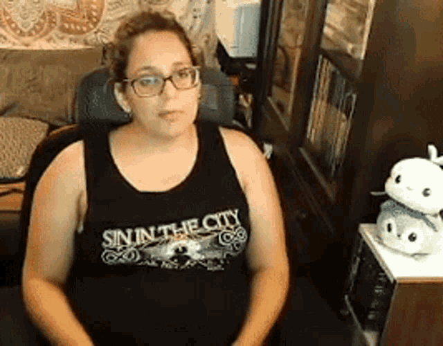 a woman wearing a sin in the city tank top