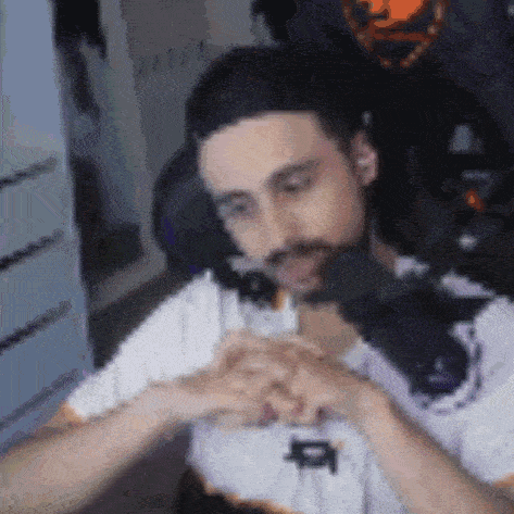 a man with a beard is sitting in a chair with headphones on and looking at something .