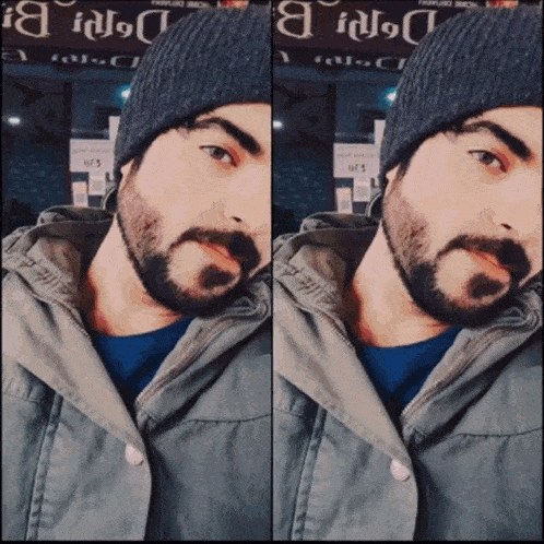 a man with a beard is wearing a beanie and jacket
