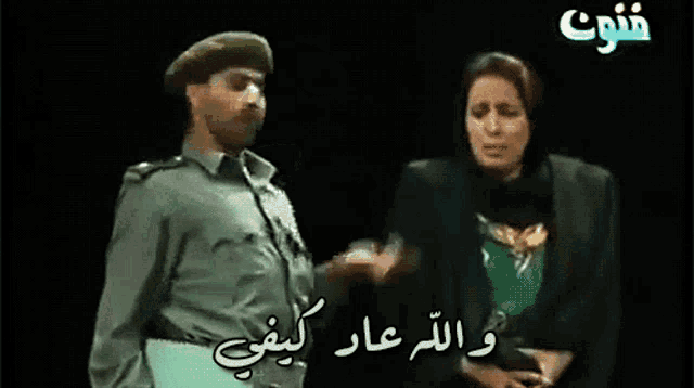 a man and a woman are standing next to each other with arabic writing on the screen
