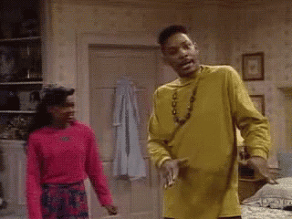 a man in a yellow shirt is standing next to a woman in a pink shirt and says mind ya business .