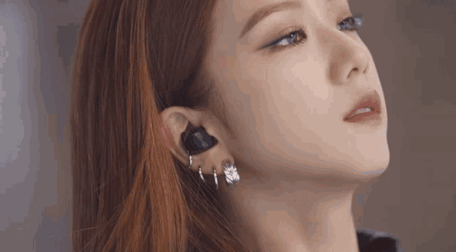 a close up of a woman 's face with earrings on her ears