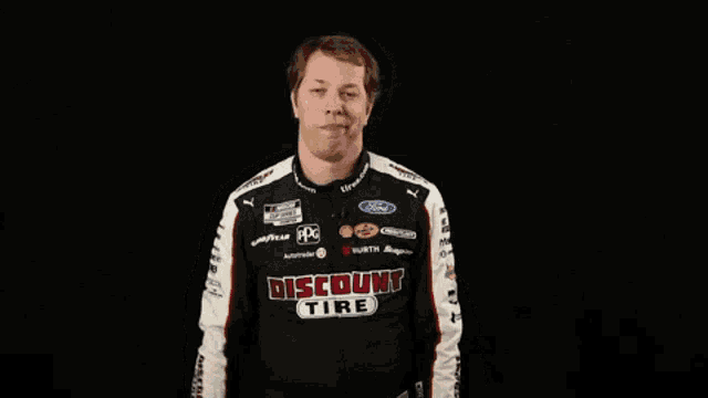 a man in a discount tire uniform makes a funny face