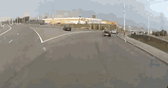 a car is driving down a highway next to a building that says ' ikea ' on it .