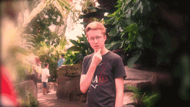 a young man wearing a black shirt that says ' a ' on it
