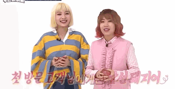 two girls are standing next to each other in front of a white background .