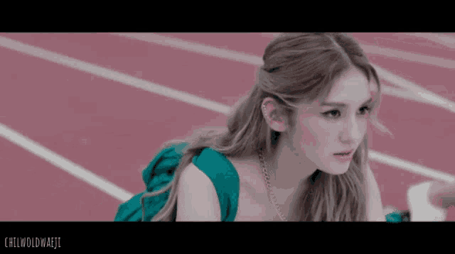 a woman in a green dress is sitting on a track with the words chilwoldmajii below her