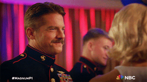 a man in a military uniform is standing next to a woman with the nbc logo on the bottom right