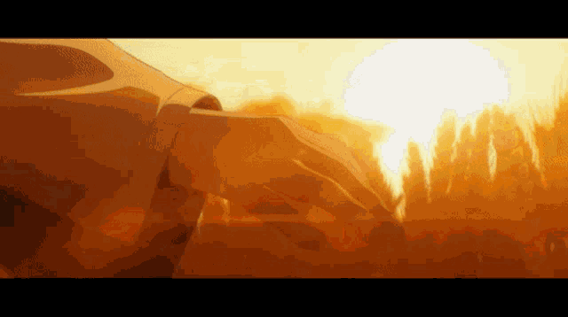 a person 's hand is reaching out towards a sunset