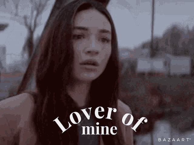 a woman is standing in front of the words lover of mine